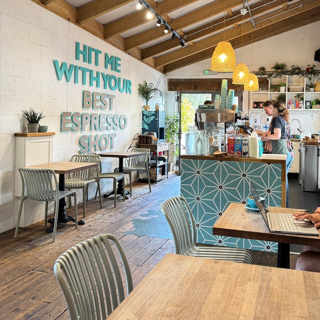 Short & Strong Café — 'Hit me with your best espresso shot' painted on a whitewashed wall.